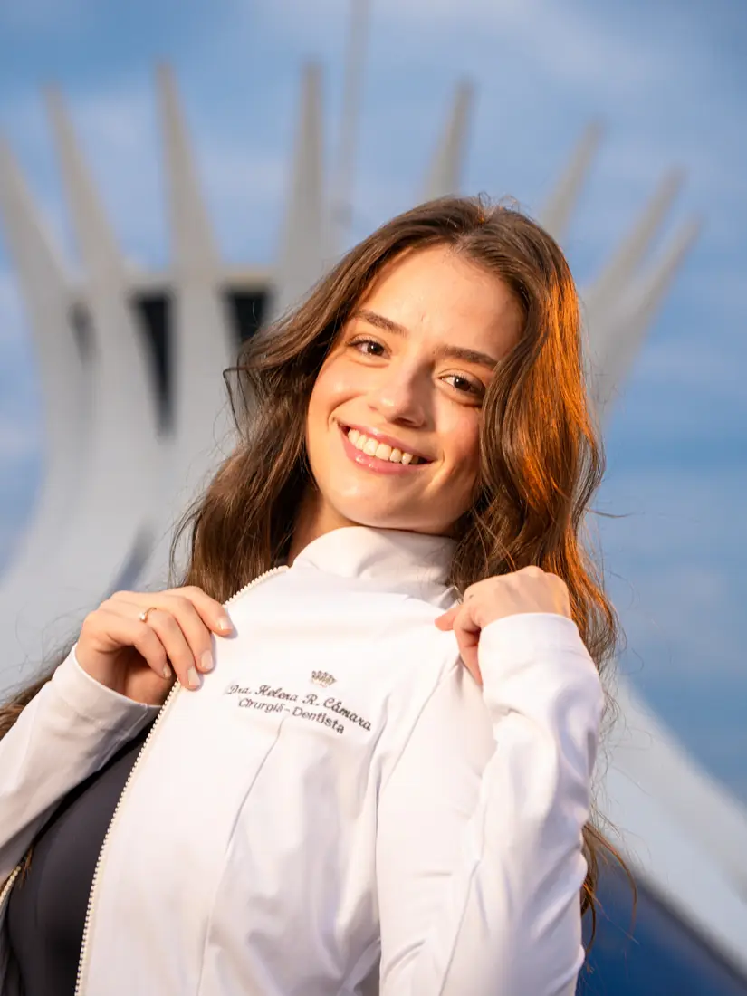 Formanda sorrindo segurando o jaleco